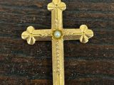 a close up of a cross on a wooden surface