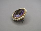 an image of a purple and white broochle with pearls on it