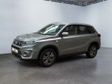 Le SUV argenté est garé dans une grande pièce aux murs blancs.