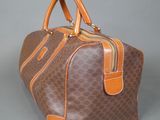 a brown and orange handbag sitting on a gray surface