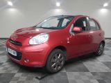 la petite voiture rouge est garée sur un sol en damier