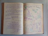 an open book with a drawing of a castle on it