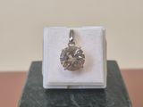 une image représentant un pendentif en diamant posé sur un bloc de marbre
