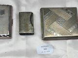 trois briquets argentés posés les uns à côté des autres sur un drap blanc