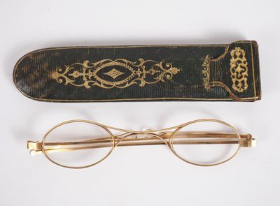 an old pair of glasses and a book on a white surface