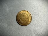a gold coin with a crown on it sitting on top of a table