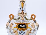 un vase blanc orné d'un motif bleu et jaune