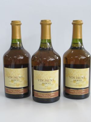 trois bouteilles de vin posées les unes à côté des autres sur une surface blanche