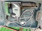a green box with a drill and a cord in it