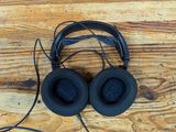 a pair of headphones sitting on top of a wooden table