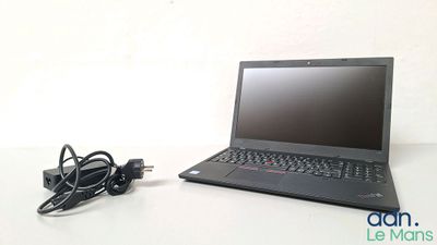 un ordinateur portable posé sur une table avec un chargeur