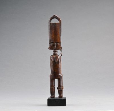 une image représentant une statue en bois d'un homme debout sur un socle