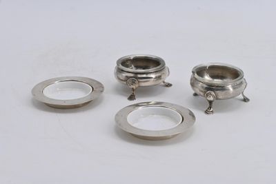 quatre pièces métalliques argentées sur une surface blanche