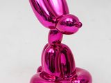 a pink balloon shaped like a rabbit sitting on top of a table