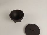 a small black bowl and a small black bowl on a white table