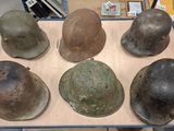 several helmets are sitting on top of a table in a warehouse