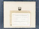 an old picture of a certificate in a frame on a table