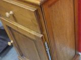 a small wooden cabinet with a drawer on top of it