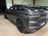 the rear end of a grey car parked in a garage