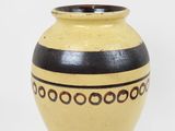 a yellow and black vase on a white background