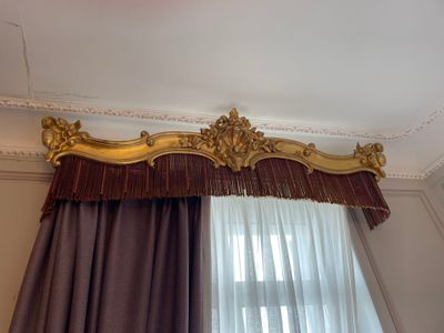 a curtain with a gold trim hanging on the wall