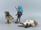trois figurines placées les unes à côté des autres sur une table