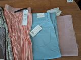 three pairs of pants are sitting on a table with a price tag