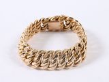 a close up of a gold bracelet on a white surface