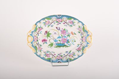 a plate with a floral design on it on a stand