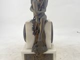 a statue of a woman sitting on a chair with a basket of grapes