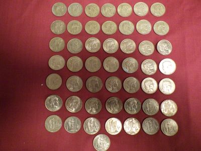 a lot of coins that are on a red cloth