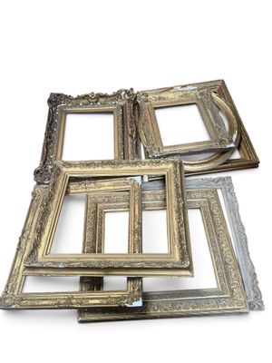 several antique picture frames are stacked on top of each other
