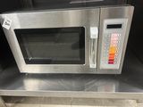 a silver microwave sitting on top of a metal counter