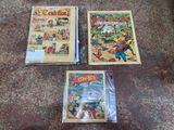 three comics are sitting on the floor next to each other