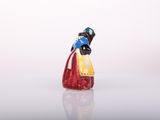 figurine of a woman in a red dress with a blue hat