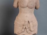 une femme debout à côté d'une statue représentant une femme les mains posées sur la poitrine