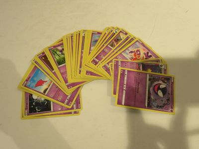 beaucoup de cartes posées sur la table, avec une ombre sur le mur