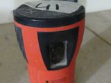 an orange and black blender sitting on top of a floor next to a white wall