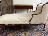 a chaise lounger sitting on a rug in a living room