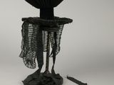 une sculpture noire surmontée d'un ventilateur