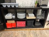 many plates and glasses on a shelf in a room