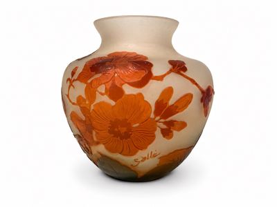 un vase orné de fleurs orange sur un fond blanc