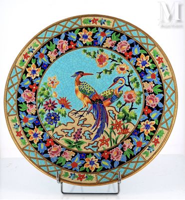 une assiette colorée ornée d'un oiseau, posée sur un socle