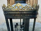 un brasero noir et doré surmonté d'une couronne