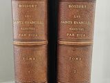 two old books sitting on top of a wooden table next to each other