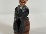 a figurine of a man sitting on top of a barrel
