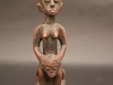 une petite figurine représentant un homme tenant un bébé dans ses bras