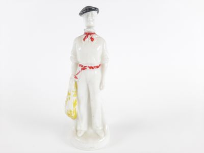 figurine en porcelaine représentant un homme avec un chapeau et un sac