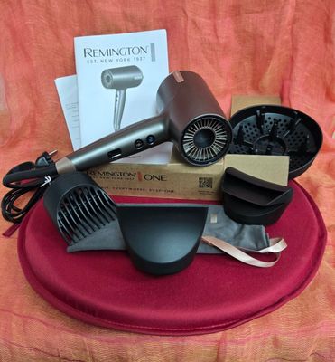 un sèche-cheveux, un peigne et d'autres objets posés sur une table