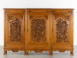une armoire en bois ornée de sculptures et de moulures sur les portes